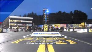 Mike McIntire pops a wheelie at the Mopar Express Lane NHRA Nationals alongside John Force